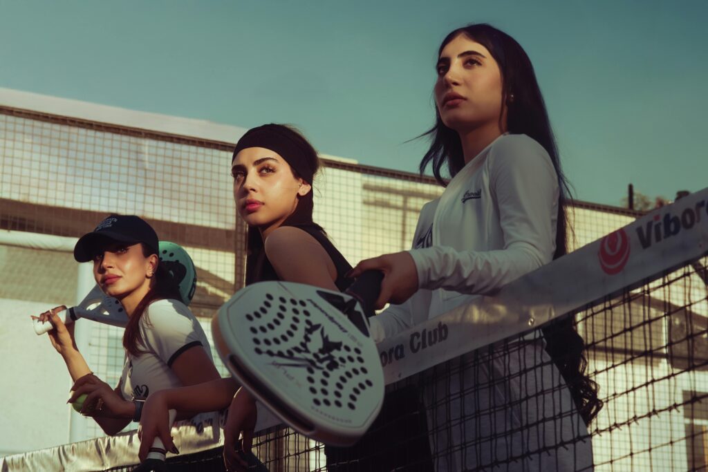 Group of college friends posing with rackets, showing the social side of padel for students in Utah.