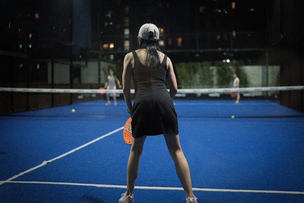 Players enjoying a match under perfect indoor lighting with zero wind interference, the ultimate pickleball alternative in Utah County.