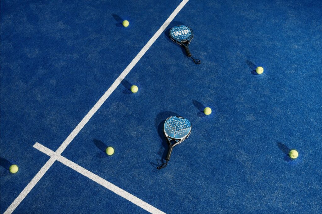 Two padel rackets resting on clean blue artificial turf, showcasing a premium pickleball alternative in Utah County.