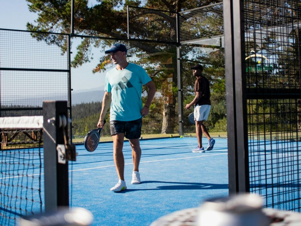 Players socializing and enjoying a drink after a match, demonstrating the fun community vibe that explains why is padel so popular.