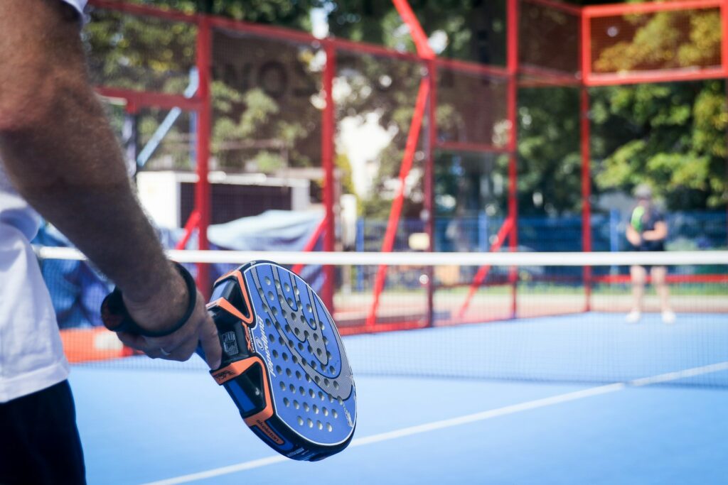 A player holding a blue racket and looking across the net, representing the massive growth and popularity of padel Utah.