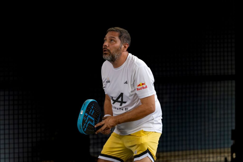 A male padel player looking up to prepare for an overhead smash, symbolizing the sport's high ambitions for the 2032 Brisbane Olympics.